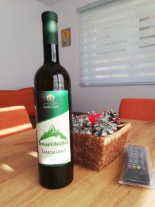 a bottle of wine sitting on a table next to a basket at Iznad oblaka A1 in Kopaonik