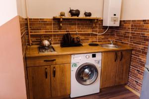 una cucina con lavatrice e lavandino di Апартаменты STONE HOUSE a Kam"janec'-Podil's'kyj
