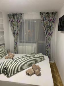 two beds in a room with striped pillows on them at Holiday Apartment in Sibiu