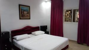 a bedroom with a large bed with red curtains at Villa Green flower in Casablanca
