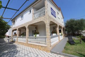 a white building with a balcony on the side at Apartments Magdalena in Vodice