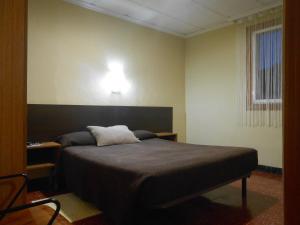 a bedroom with a bed and a light on the wall at Hostal El Callejón in Tarragona