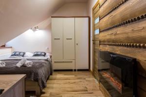 1 dormitorio con 1 cama y chimenea en Apart Styl Apartament Róża Pustyni, centrum miasta, en Zakopane