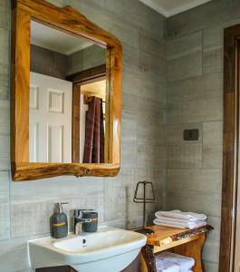 een badkamer met een wastafel en een spiegel bij Entre Volcanes Lodge in La Ensenada