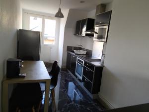 a kitchen with a table and a counter top at Bel appartement en plein coeur de ville in Le Creusot +7 photos