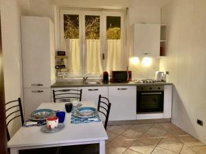 kuchnia z białym stołem i krzesłami oraz stołem i tableablish w obiekcie Kibilù - Via Magenta 31 Centro Città con Parcheggio w mieście Varese +18 zdjęć