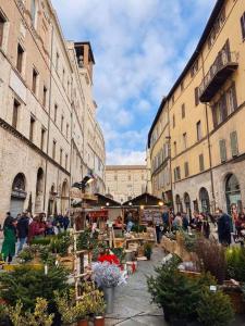 a group of people walking around a market in a city at Appartamento Via Alessi in Perugia