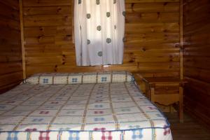 a bedroom with a bed and a window in a cabin at Camping La Puerta in Moratalla