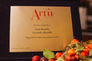 Bianzoneにあるアルタヴィラ ロカンダ エ ティピカ トラットリアのテーブルに果物一杯の看板