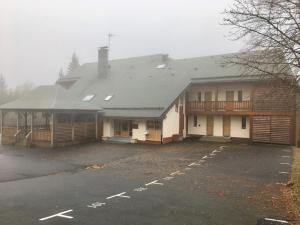 Uma casa com um parque de estacionamento à frente. em La Randonnée Résidence Le Bec de L'Aigle em Le Lioran