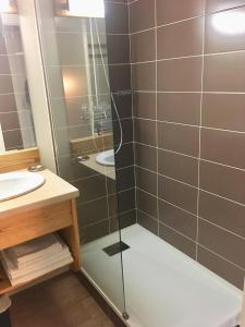 La salle de bains est pourvue d'une douche avec une porte en verre. dans l'établissement La Randonnée Résidence Le Bec de L'Aigle, à Le Lioran