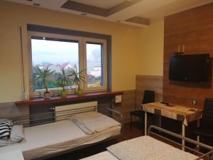 a room with two beds and a window and a table at Eldom-Noclegi Pracownicze Daleka 12 in Wągrowiec