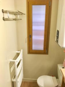 uma casa de banho com um WC e uma janela em La Randonnée Résidence Le Bec de L'Aigle em Le Lioran