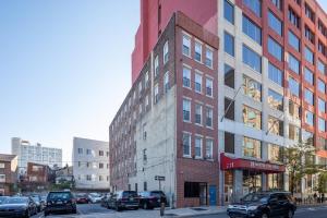 a tall building on a city street with parked cars at The Stairway Suites - Convention Center in Philadelphia