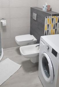 ein Badezimmer mit einem WC und einer Waschmaschine in der Unterkunft Apartament RODZINNY Wałowa Wejherowo in Wejherowo