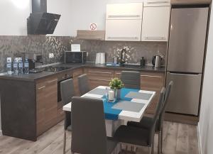 a kitchen with a table with chairs and a refrigerator at Apartament RODZINNY Wałowa Wejherowo in Wejherowo