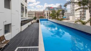 einem Pool an der Seite eines Gebäudes in der Unterkunft Auckland Harbour Suites in Auckland