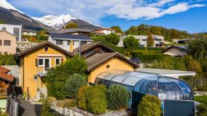 une maison avec une serre dans un quartier résidentiel dans l'établissement O Rendez Vous maison mitoyenne Piscine chauffée mars-octobre, à Grimisuat