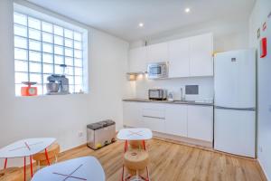 a kitchen with two tables and a refrigerator at Sleepyfig in Sagres