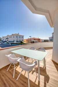 a white table and chairs on a balcony at Sleepyfig in Sagres