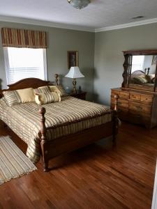 a bedroom with a bed and a dresser and a mirror at Downtown abode in the heart of the Bourbon Trail in Lebanon