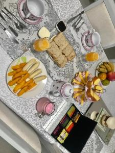 una mesa cubierta con platos de comida y fruta en Luna, bed&breakfast, en Bombinhas