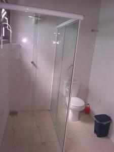 ein Badezimmer mit Glasdusche und Toilette in der Unterkunft casa de dois quartos para até 6 pessoas in Ubatuba