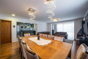 uma sala de jantar com uma mesa de madeira e cadeiras em Luxuoso Apartamento no Coração de Gramado em Gramado