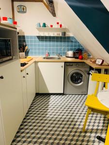 a kitchen with a sink and a washing machine at La maison de Nina in Sens