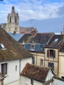 a view of roofs of buildings with a clock tower at La maison de Nina in Sens