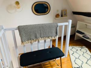 a white crib with a black and white blanket on it at La maison de Nina in Sens