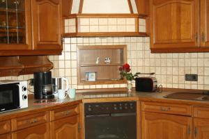 a kitchen with wooden cabinets and a stove top oven at Ferienhaus Cilla in Beltheim