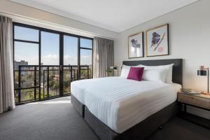 Uma cama ou camas num quarto em Avani Metropolis Auckland Residences
