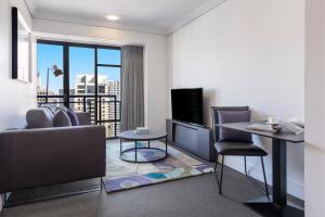奧克蘭的住宿－Avani Metropolis Auckland Residences，客厅配有沙发和桌子