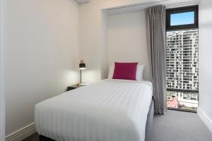 Uma cama ou camas num quarto em Avani Metropolis Auckland Residences