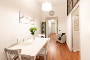a white dining room with a white table and chairs at Leonardo Suite Pantheon in Rome