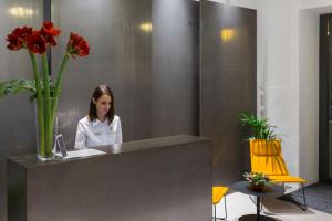 a woman sitting at a reception desk in a lobby at MANDA Heritage Hotel in Zagreb