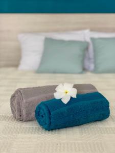 - une serviette bleue avec une fleur blanche sur un lit dans l'établissement Ti Bleu • Studio vue mer & accès plage, au Gosier