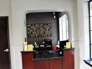 a office with a counter with a mirror above it at Cityview Inn & Suites Downtown /RiverCenter Area in San Antonio