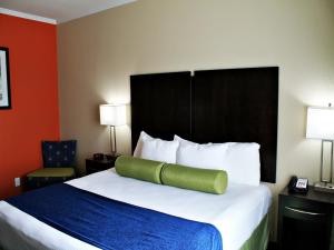 a hotel room with a bed with a green pillow on it at Cityview Inn & Suites Downtown /RiverCenter Area in San Antonio