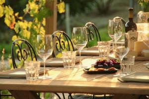 einen Holztisch mit Weingläsern und Essen darauf in der Unterkunft Villa La Mura - Luxury Pool by the Vineyard in Costigliole dʼAsti
