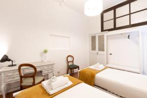 a bedroom with two beds and a desk and a chair at Leonardo Suite Pantheon in Rome +24 photos
