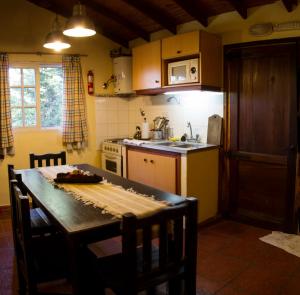 a kitchen with a table and a sink and a stove at Cabañas MARE PARADISO in Costa del Este