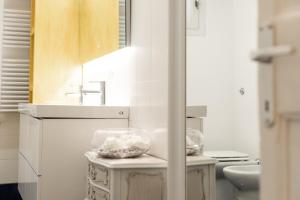 a white bathroom with a sink and a mirror at Leonardo Suite Pantheon in Rome