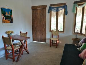 a living room with a wooden table and chairs at Kunda'Vi in Mazunte