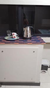 a tea kettle and a cup on a table at LUXURY APARTMENT PUERTO SANTA ANA GUAYAQUIL in Guayaquil