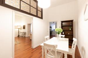 a dining room and living room with a white table and chairs at Leonardo Suite Pantheon in Rome
