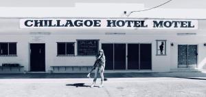 a man walking down the street with a skateboard at Chillagoe Cockatoo Hotel Motel in Chillagoe