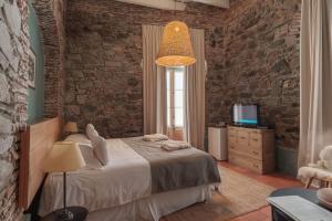a bedroom with a bed and a brick wall at Posada Plaza Mayor in Colonia del Sacramento