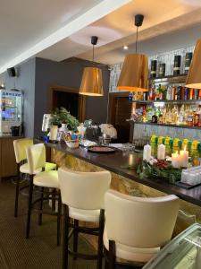 um bar num restaurante com cadeiras amarelas e luzes em Aparthotel Kamzík em Donovaly